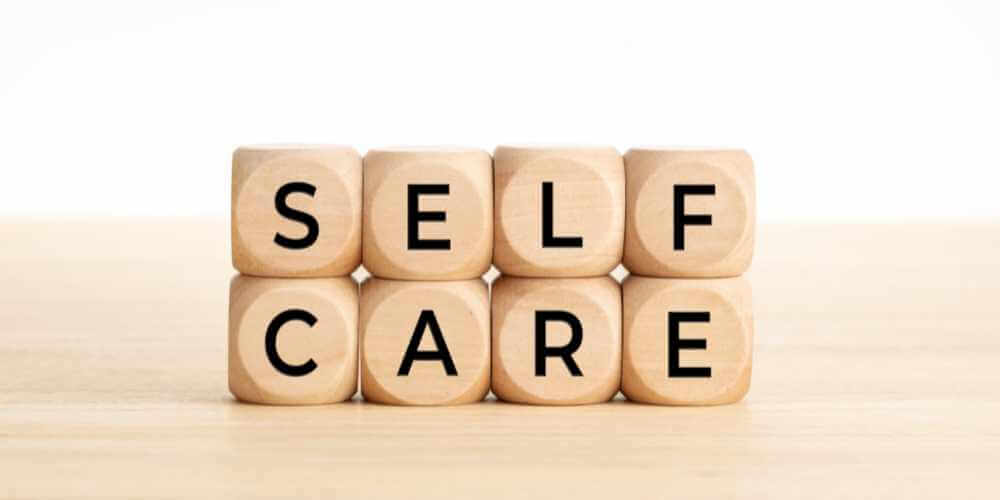 Würfel mit Buchstaben formen das Wort Self Care – Selbstfürsorge lernen für mehr Wohlbefinden und innere Stärke