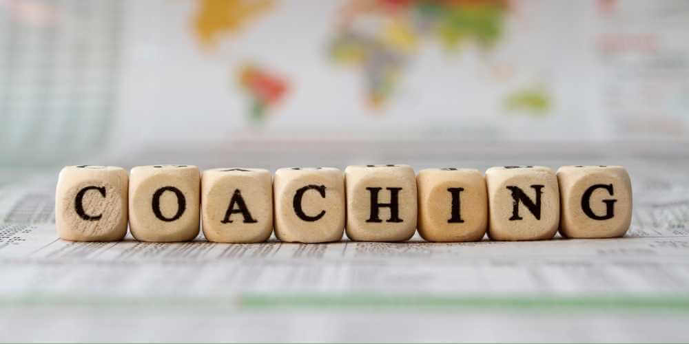 Würfel mit Buchstaben formen das Wort Coaching – psychosoziale Beratung für persönliche Entwicklung